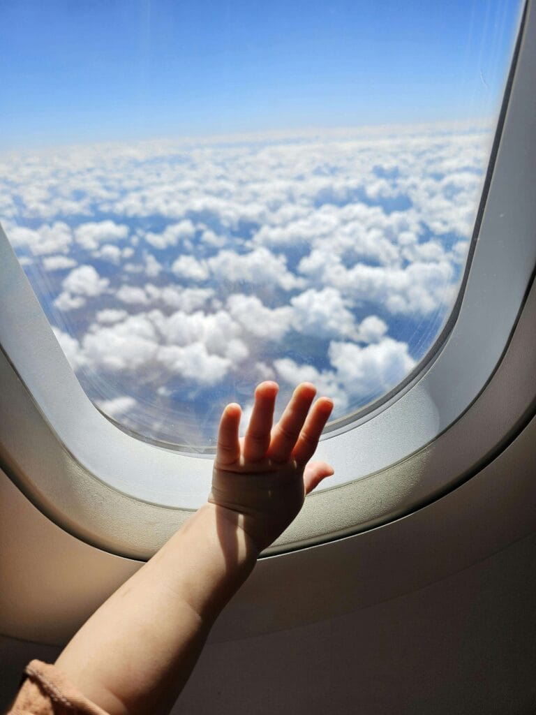 mãozinha de criança na janela do avião