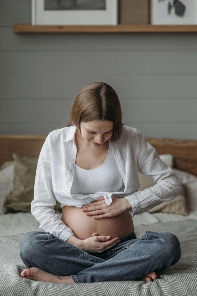 mulher grávida com a mão na barriga, no segundo trimestre de gravidez