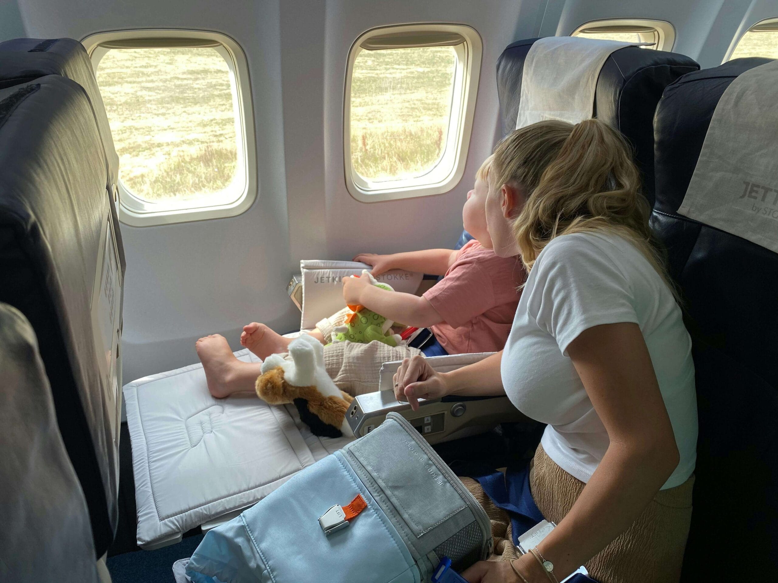 como viajar de avião com crianças, mãe e filha dentro do avião olhando pela janela